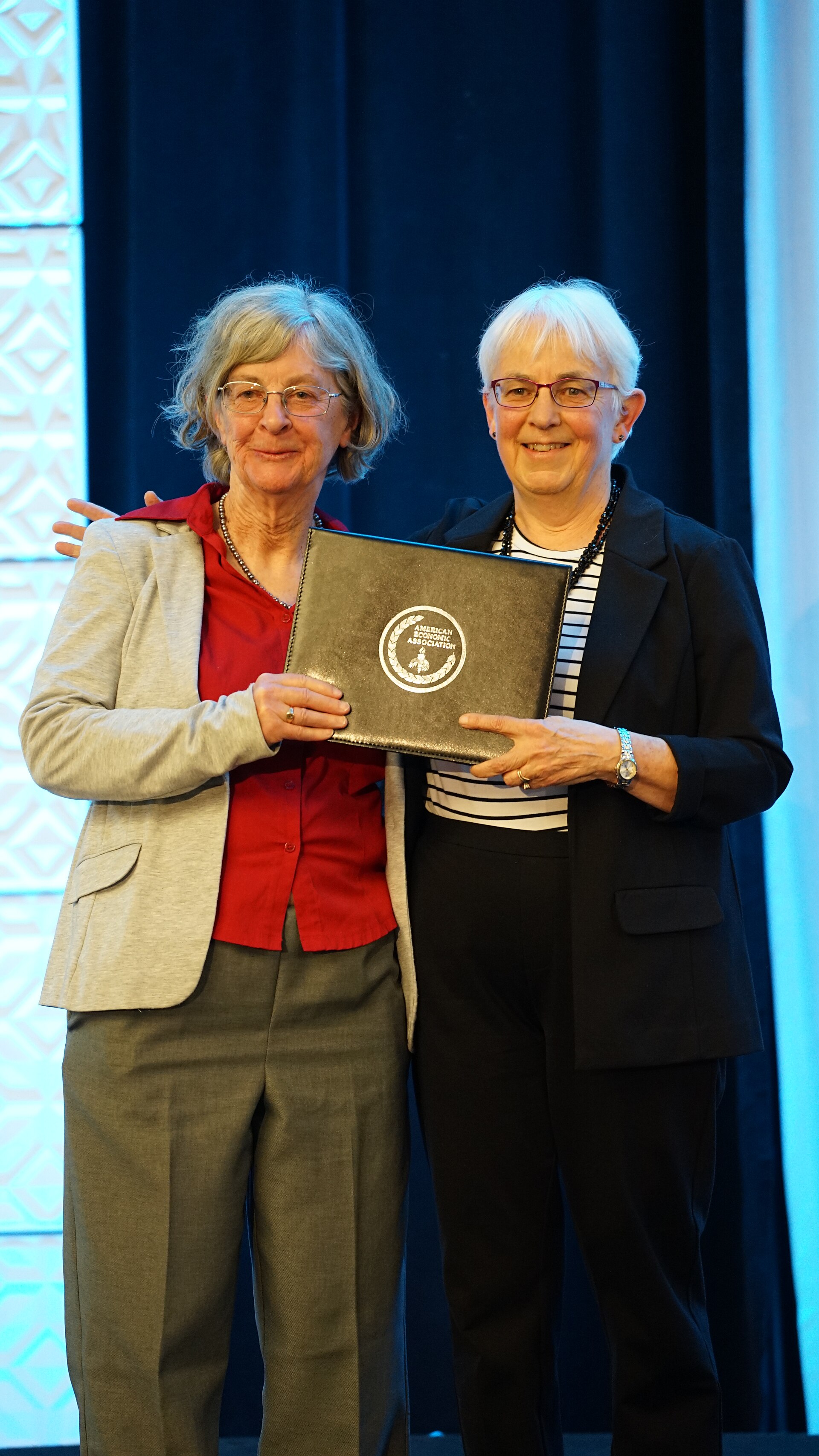 Barbara Fraumeni getting Distinguished Fellow award from Katharine Abraham at the ASSA (AEA) Annual Meeting 2026 in Philadelphia, PA