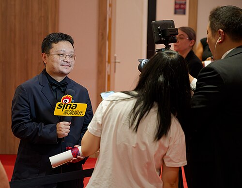 Bi Gan being interviewed by press after winning an award at the 2025 Cannes Film Festival.