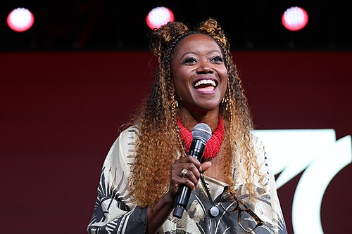 Erika Alexander smiling on the main stage during a Q&A at Essence Fest 2025