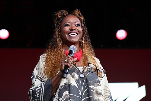 Erika Alexander smiling on the main stage during a Q&A at Essence Fest 2025