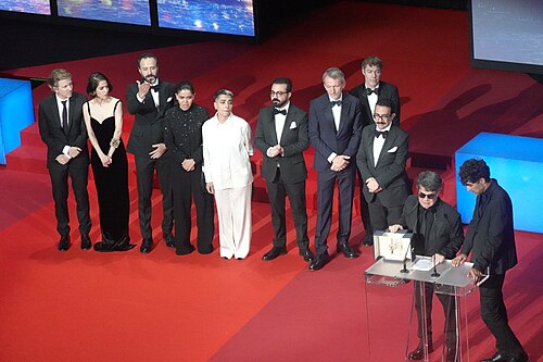 Director Jafar Panahi accepting Palme d'Or for Un Simple Accident at Cannes 2025 with cast and crew