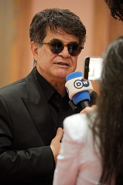 Jafar Panahi being interviewed by press after winning an award at the 2025 Cannes Film Festival.