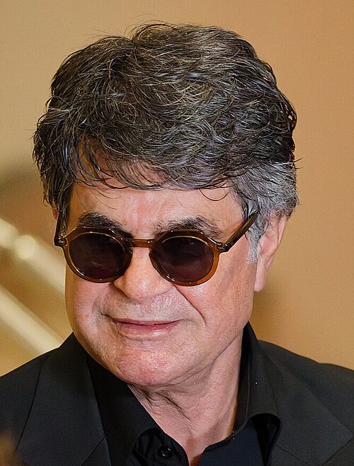Jafar Panahi being interviewed by press after winning an award at the 2025 Cannes Film Festival.