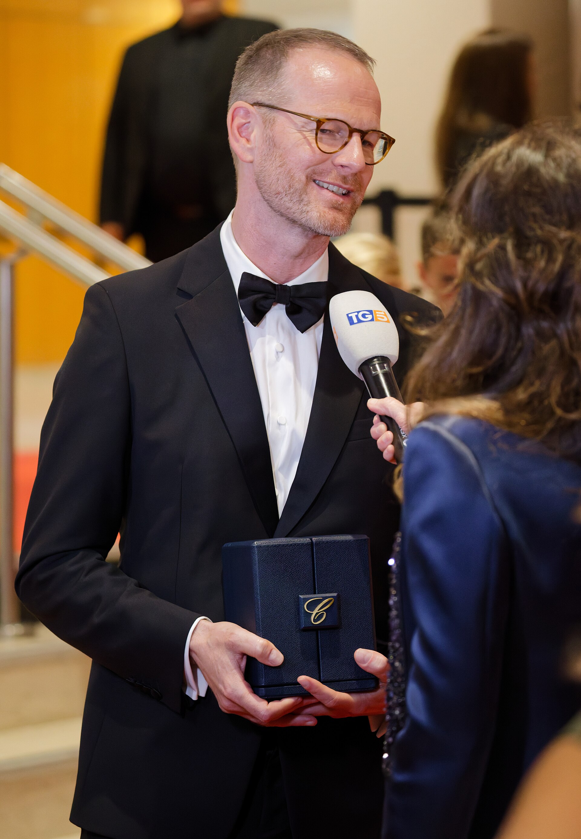 Joachim Trier being interviewed by press after winning an award at the 2025 Cannes Film Festival.