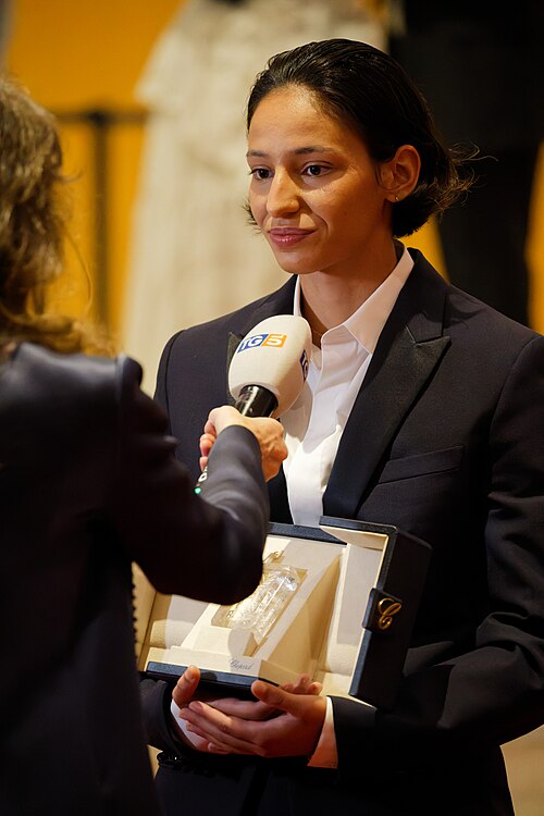 Nadia Melliti being interviewed by press after winning an award at the 2025 Cannes Film Festival.