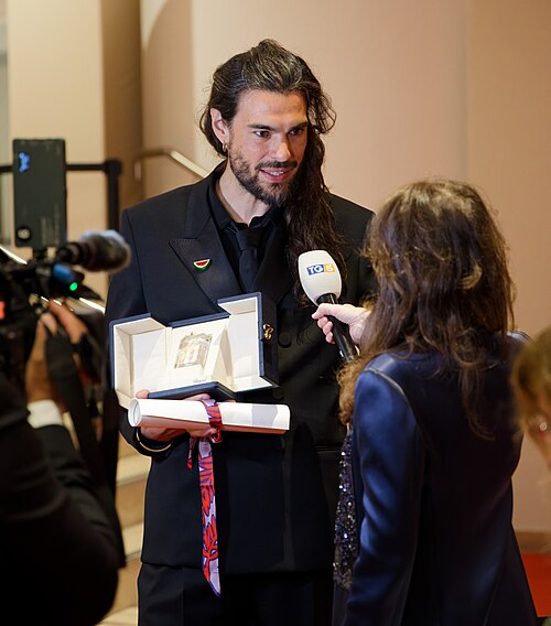 Oliver Laxe being interviewed by press after winning an award at the 2025 Cannes Film Festival.