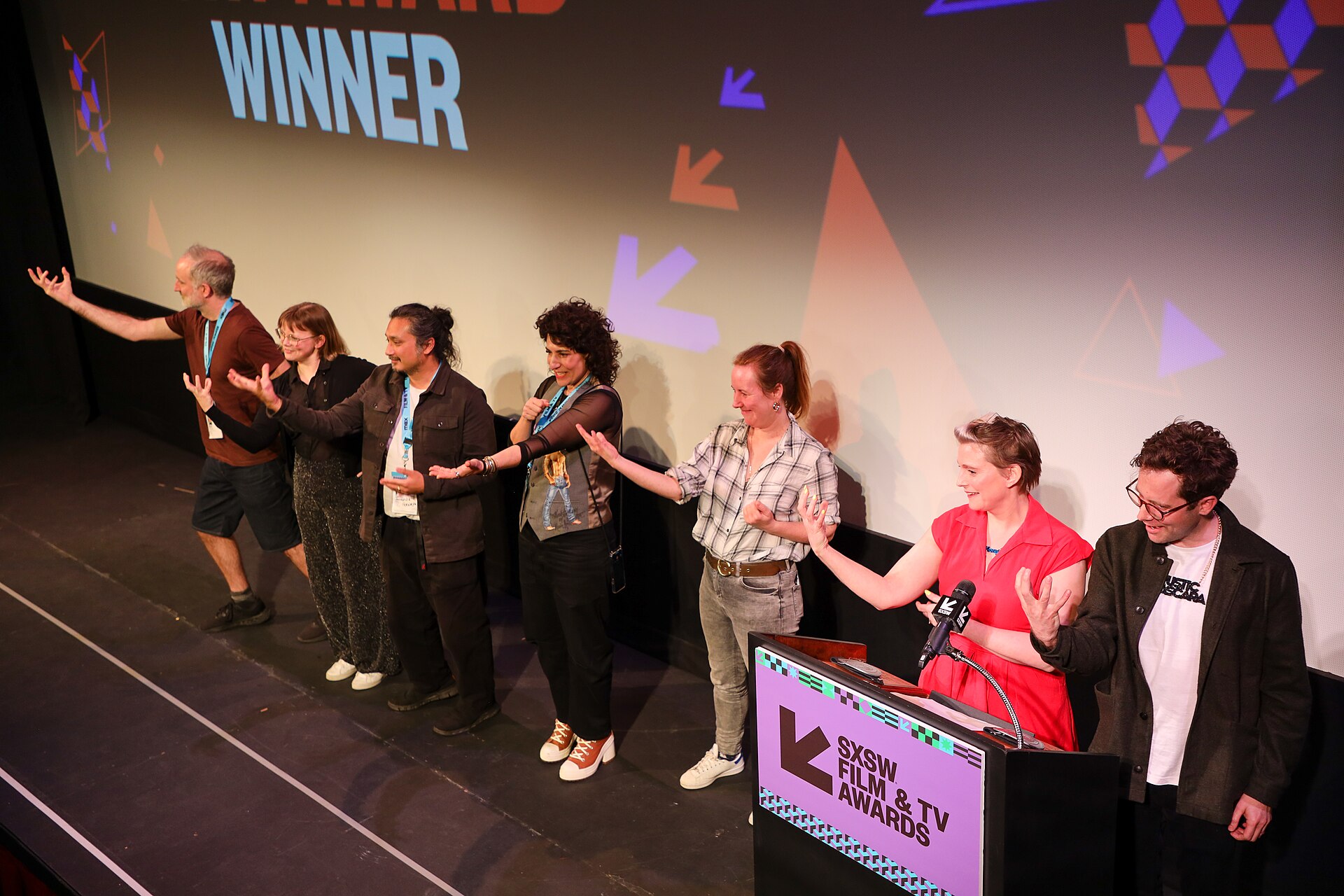 Cast and crew of Grand Theft Hamlet on stage and performing British Sign Language at the SXSW 2024 Film Festival award ceremony that took place at the Paramount Theatre in Austin, Texas. The film won the SXSW 2024 Documentary Feature Competition Award.