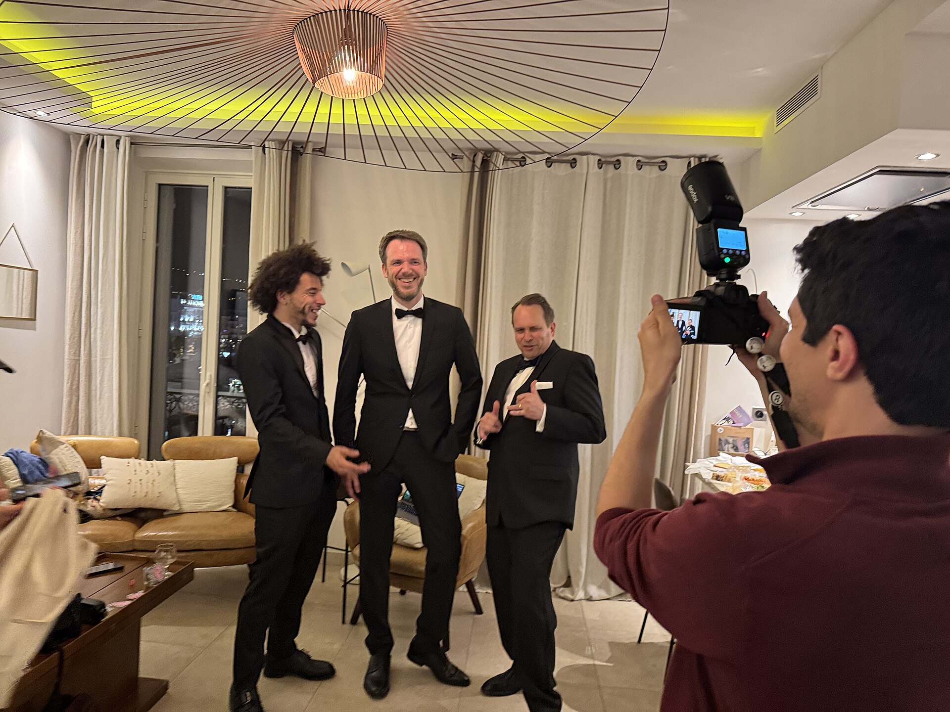 Kevin Payravi taking a photo of Gabriel Redd Hutchinson, Harald Krichel and Martin Kraft at Cannes Film 2025