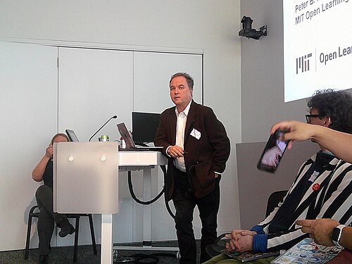 Photograph of American writer and teacher Peter B. Kaufman at the Wikipedia 25 event at MIT.  He is speaking at a panel discussion.