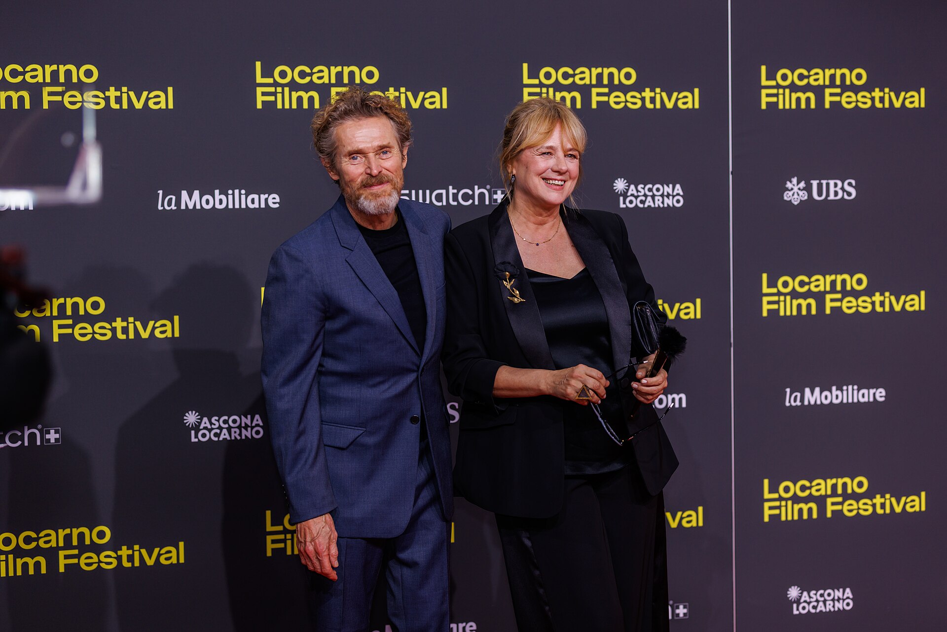 Willem Dafoe and Emma Suarez attend the 'The Birthday Party' red carpet during the 78th Locarno Film Festival on August 07, 2025 in Locarno, Switzerland.