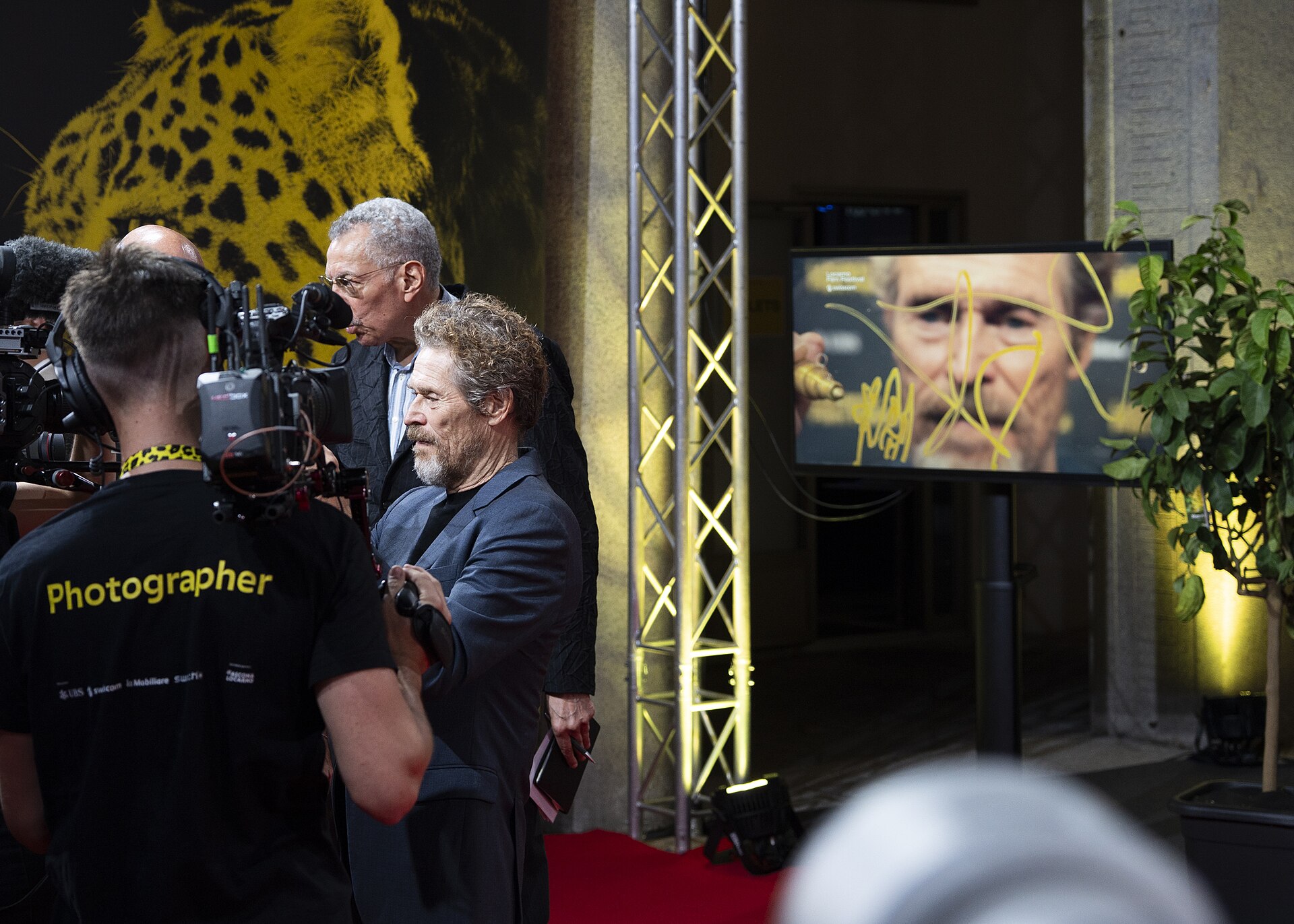 Actor Willem Dafoe signing lens at 78th Locarno Film Festival red carpet for The Birthday Party