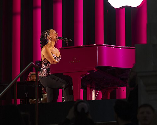 Alicia Keys performs at a bright pink Yamaha grand piano during Apple’s 50th-anniversary kickoff event at the company’s Grand Central Terminal store in New York City on March 13, 2026.