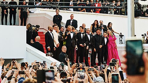 The cast of asteroid city wave to the crowd during the Cannes Film Festival in 2023