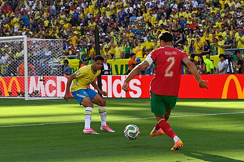 EAST RUTHERFORD, UNITED STATES - June 14: Douglas Santos of Brazil competes for the ball against Achraf Hakimi of Morocco during the FIFA World Cup 2026 Group C match between Brazil and Morocco on June 14, 2026