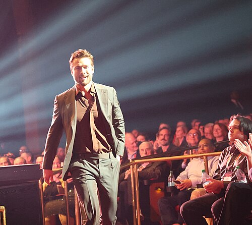 Glen Powell walking to stage at CinemaCon 2025 where he was honored with the Star of the Year at the Screen Achievement Awards at Caesar's Palace at Las Vegas, NV