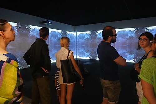 Viewers in front of Lebanese video artist Walid Raad's installation at Unlimited section of Art Basel 2025