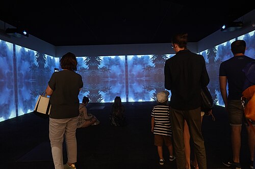 Viewers in front of Lebanese video artist Walid Raad's installation at Unlimited section of Art Basel 2025
